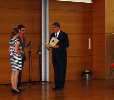 Die Chefredaktion nimmt die Auszeichnung durch Staatssekretär Prof. Dr. med. Deufel entgegen.